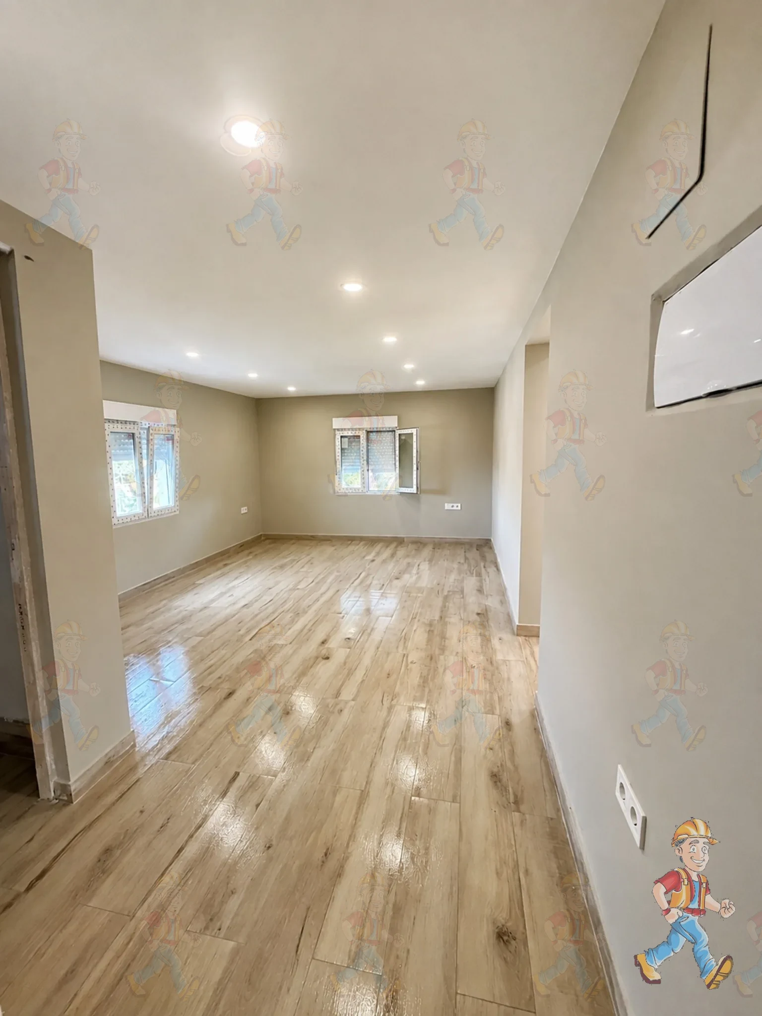 Salón de una vivienda en Alicante terminado tras la reforma: suelo símil madera, pintura y luminarias empotradas
