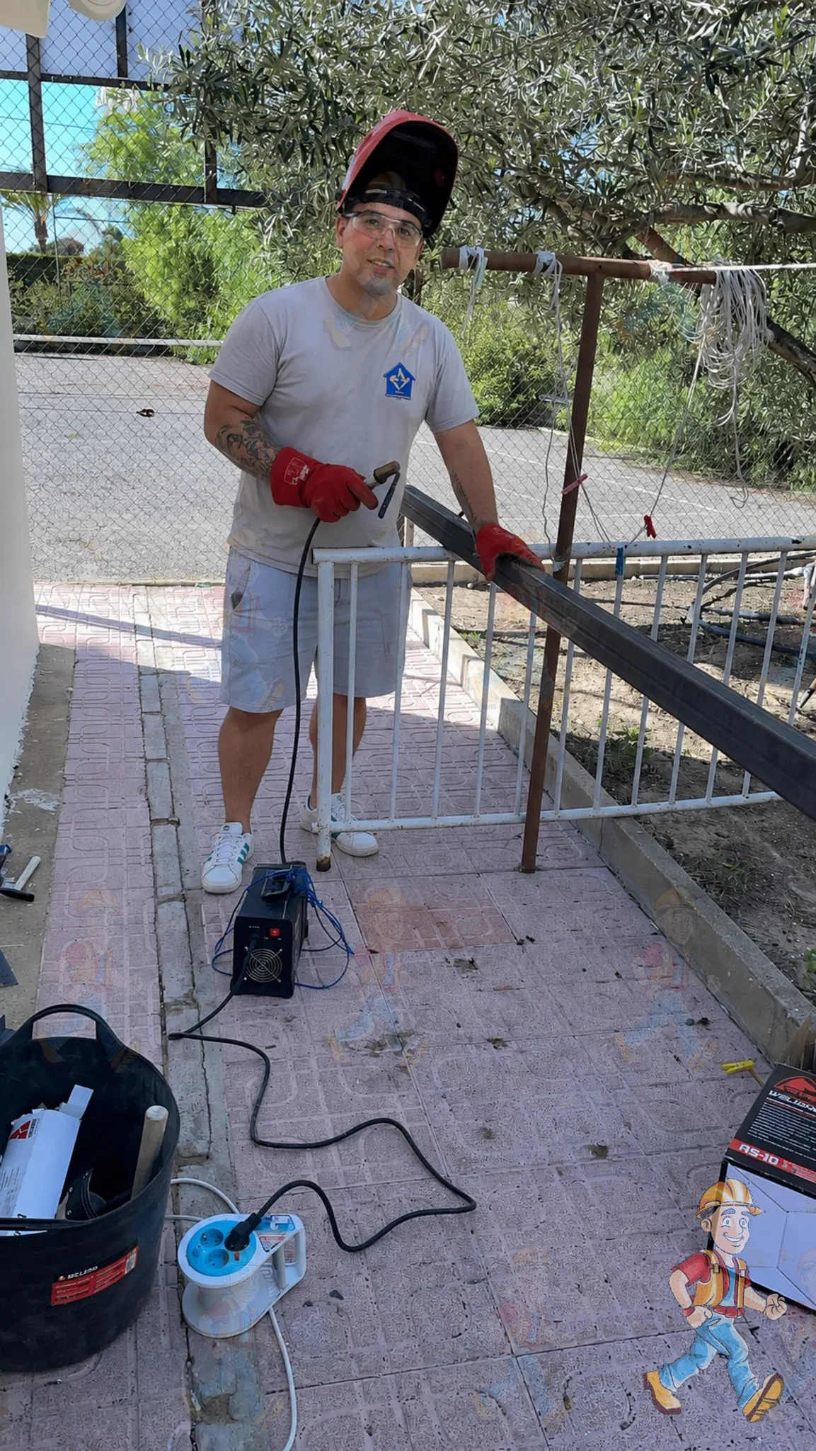 Juan soldando una estructura metálica en el exterior de una vivienda en Alicante, con equipo de protección